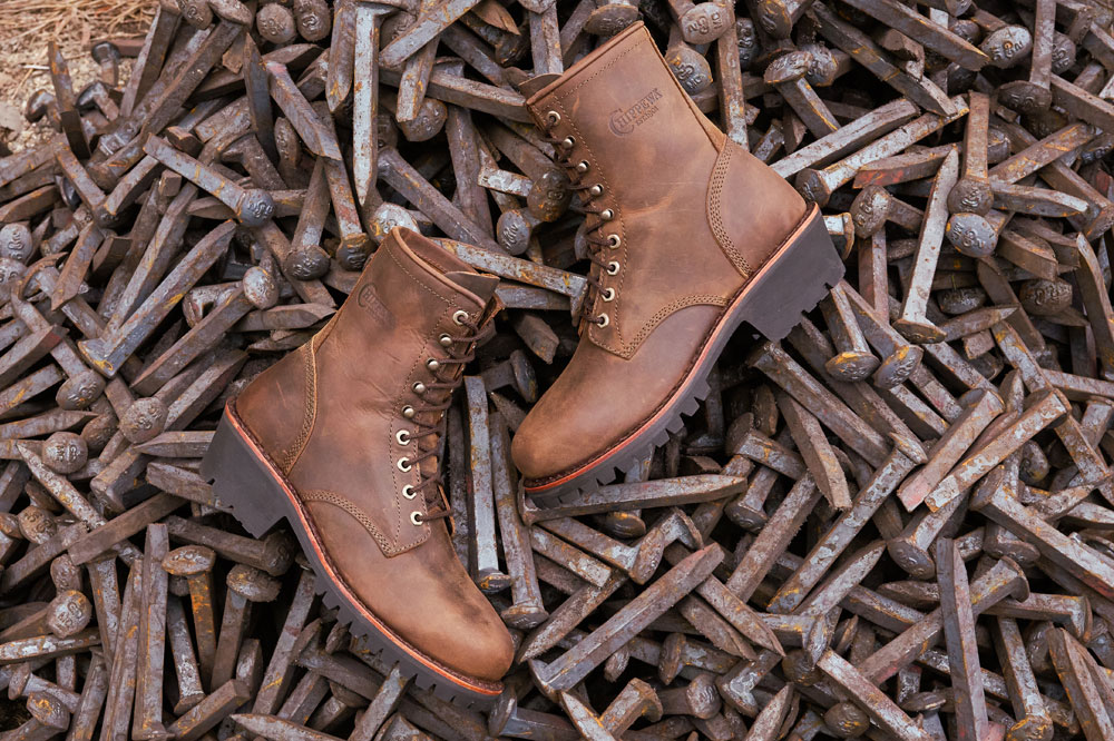 A pair of Classic 2.0 unlined steel toe loggers displayed on a pile of rail spikes.